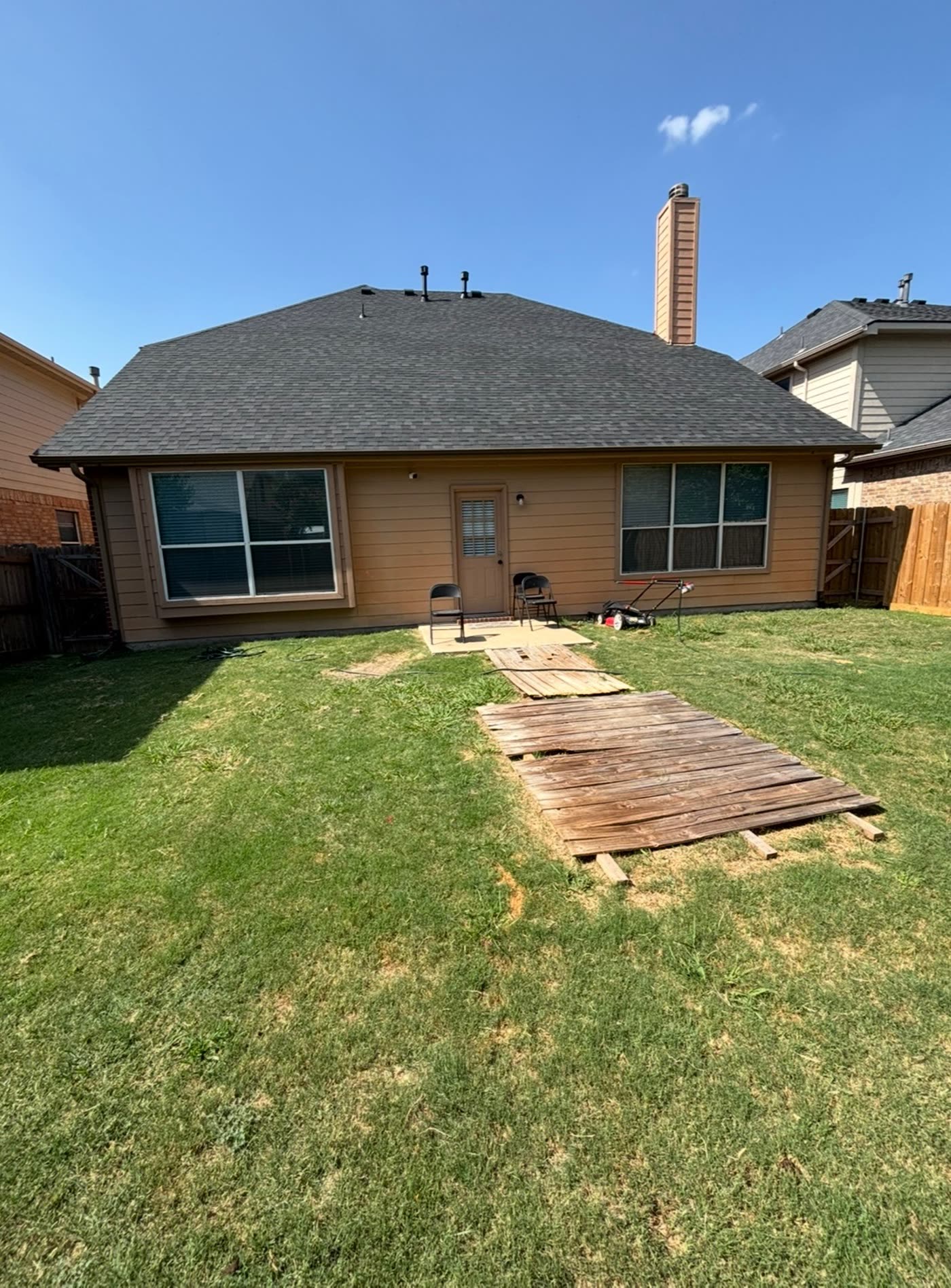 Backyard before: small concrete stoop and loose deck boards on the lawn, Fort Worth TX